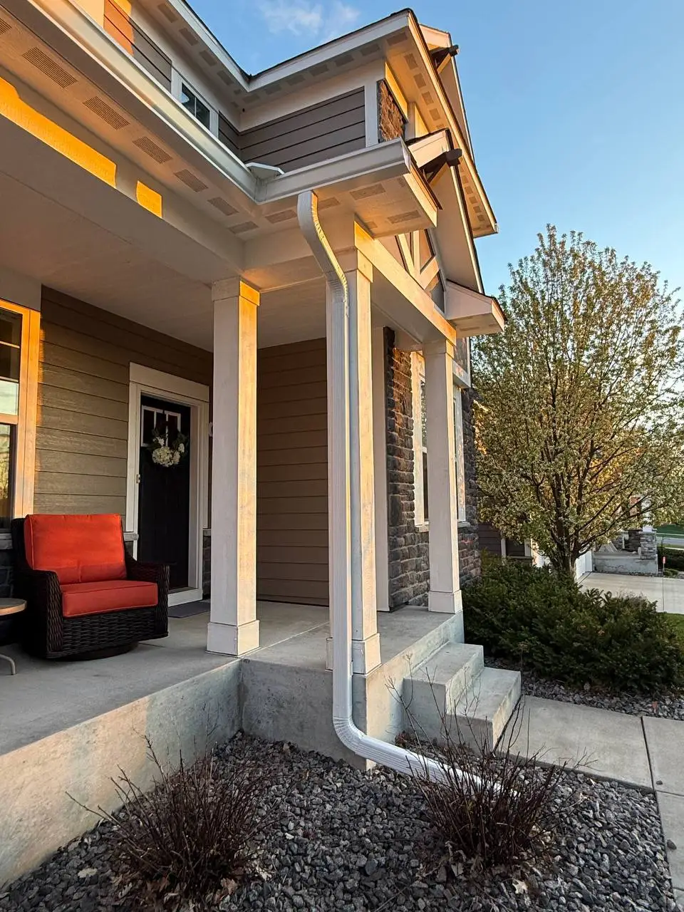White seamless gutters and downspout neatly installed on a front porch column in Delano.