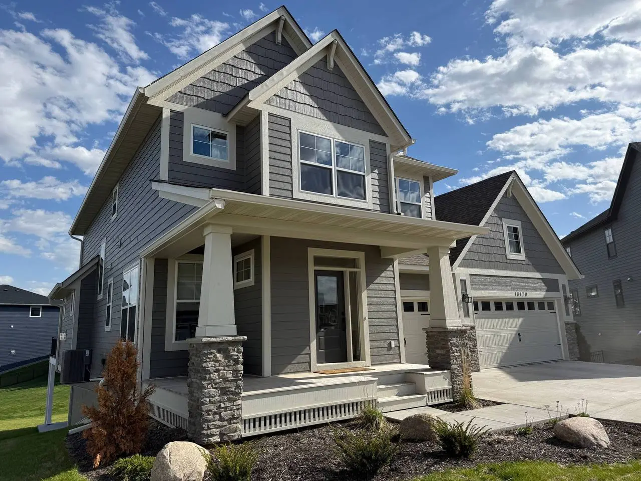 Beautiful white seamless gutter installation on a modern home's front porch and multi-level roof in Delano, enhancing curb appeal.