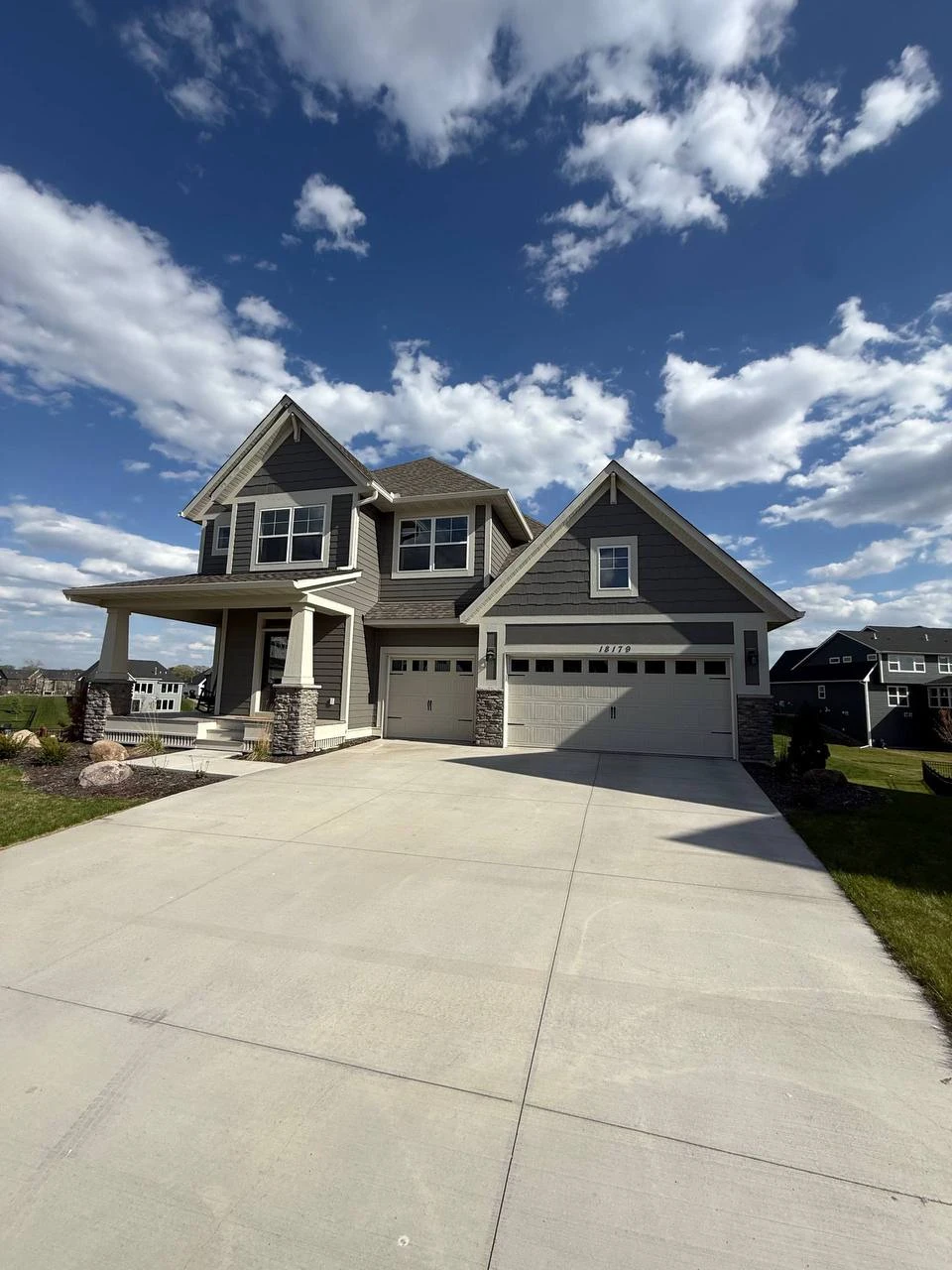 Full exterior view of a large residential home in Delano featuring a complete custom white seamless gutter installation.