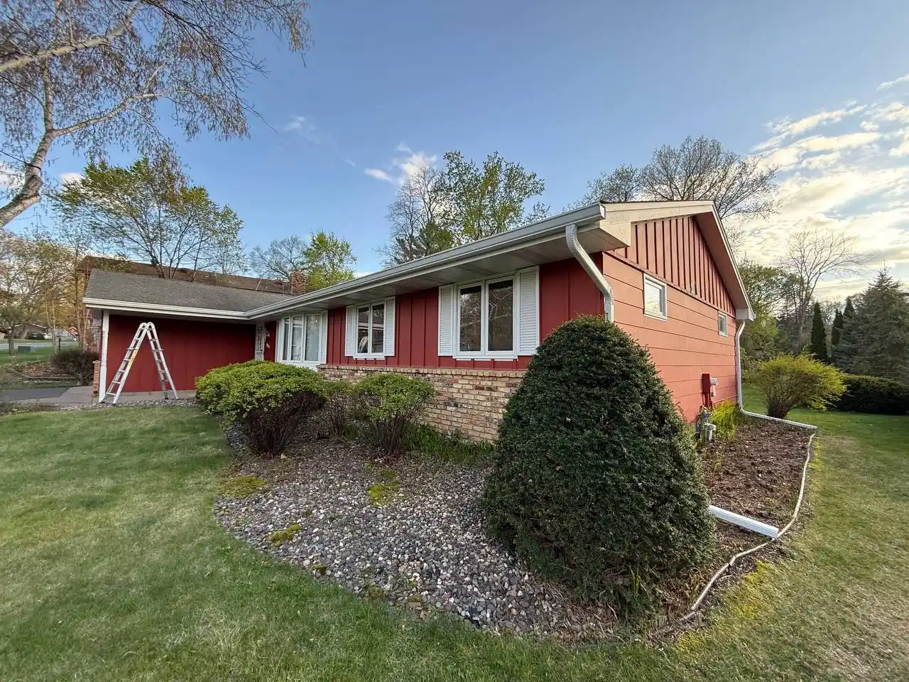 Front view of a red home with newly installed white seamless gutters in Eden Prairie